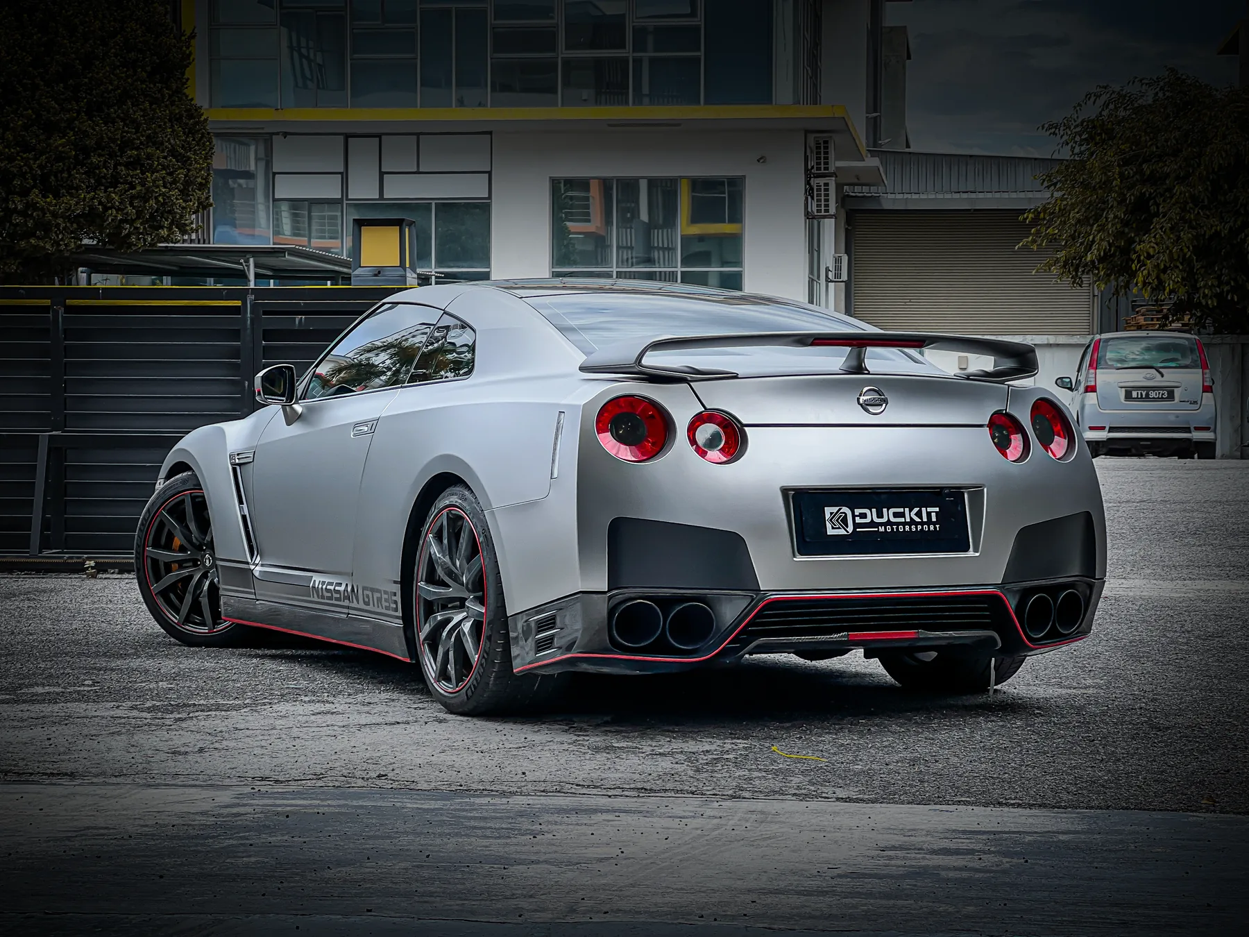 Silver Nissan GT-R R35 rear three-quarter view outside the workshop